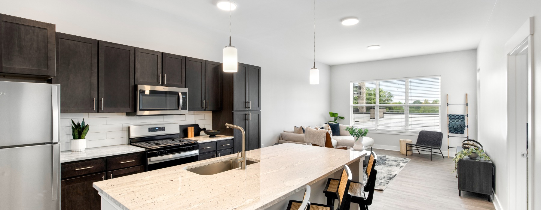 a kitchen with dark cabinets and stainless steel appliances