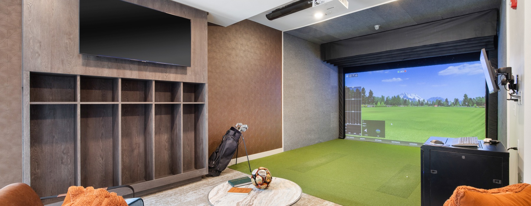 The recreation lounge at McDowell Point apartments in Naperville, IL, featuring a virtual golf simulator and couches.