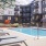 The pool area at McDowell Point apartments in Naperville, IL, featuring lounge chairs and umbrellas.