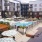 Pool area at McDowell Point apartments in Naperville, IL, featuring lounge chairs, a fire pit, and umbrellas.