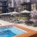 The pool area at McDowell Point apartments in Naperville, IL, featuring lounge chairs and umbrellas.