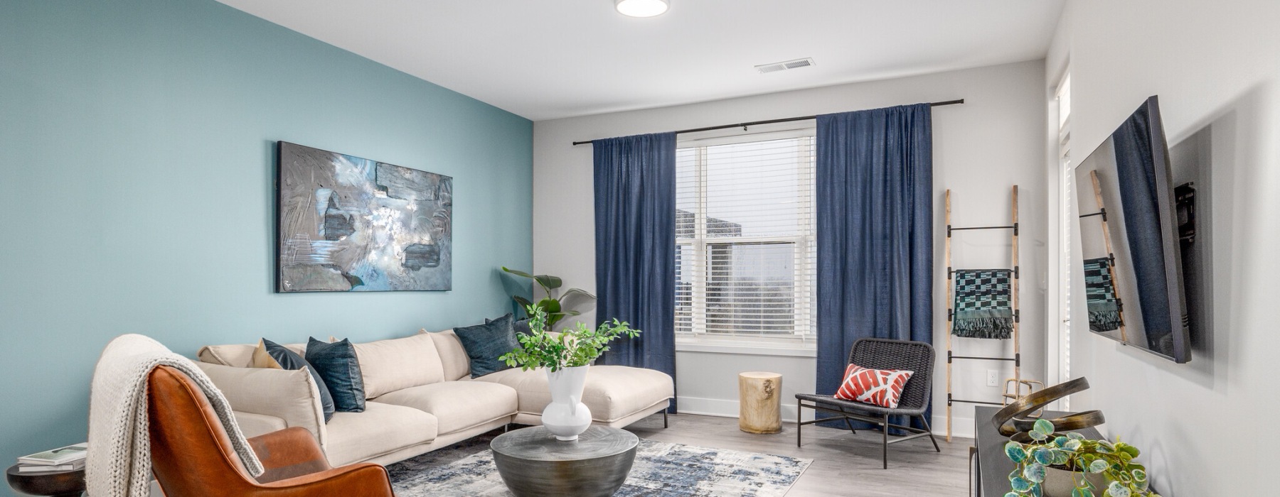 Model living room at McDowell Point apartments in Naperville, IL, featuring wood grain flooring and couches.